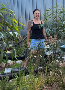 Person standing in lush green garden.